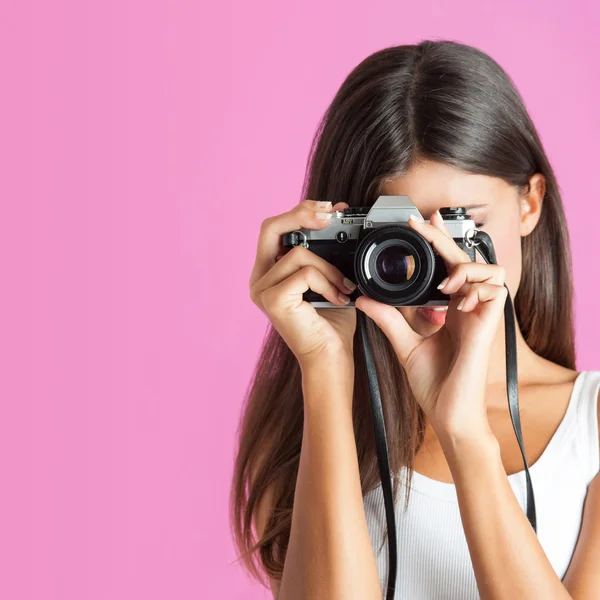 Vrouw met camera sluiten tegen roze achtergrond. — Stockfoto