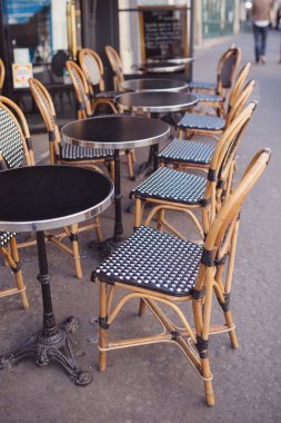 Tables and wicker chairs in cafe clipart
