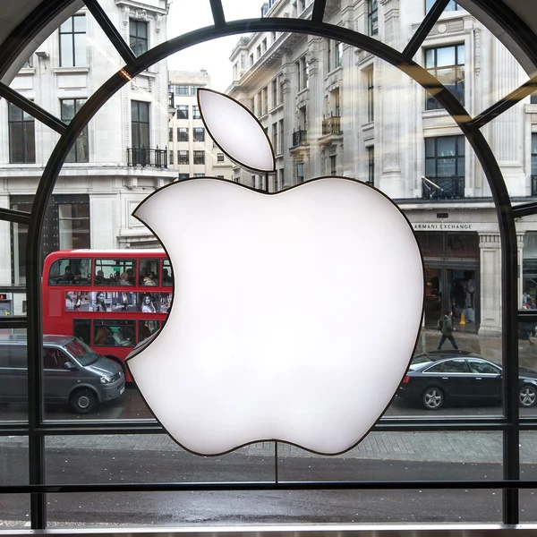 London - 12. April 2013: Apple-Logo auf dem Schaufenster des Apple Stores. Stand 2014 beschäftigt Apple 72.800 feste Vollzeitmitarbeiter, unterhält 437 Einzelhandelsgeschäfte in fünfzehn Ländern. — Stockbild Apple-Logo auf Schaufenster des Apple-Geschäfts — Stockfoto