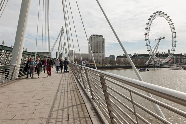 Mensen lopen over Golden Jubilee bruggen — Stockfoto