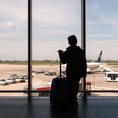 Kid looking at airplanes in the airport in Bologna