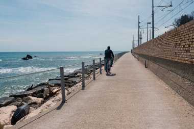 Unidentified man riding bike on the beach