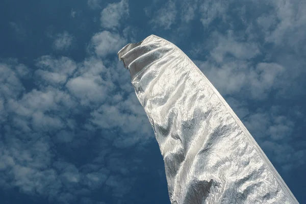 Срібний прапор на тлі блакитного хмарного неба — стокове фото