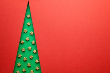 Noel ağacı asgari konsept. Altın yıldızlı yeşil Noel ağacı. Uzayı kopyala Kırmızı arka plan. Üst görünüm