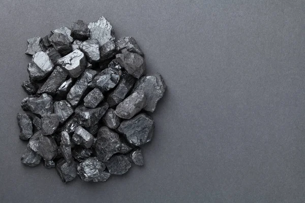 Black coal pile over graphite background. Copy space. Top view