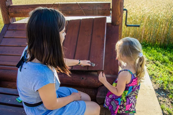 İki kız iyi ahşap kapağı açılır
