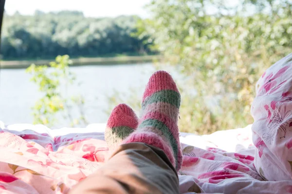 women's feet in socks in nature in the car. Summer tourism and recreation