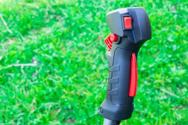 Yeşil çimen arka planında bahçe süsleme kolu. Bahçe aletleri ve çim biçme için servis kavramı.