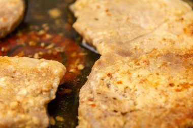 Kızarmış biftekler yakın plan. Yağ ve yağ dolu bir tavada pişmiş et. Proje ve tasarım için soyut arkaplan.