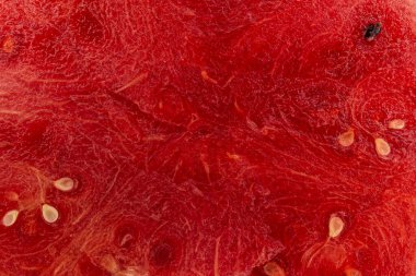 Bir karpuzun içindeki bir dilimin yakın plan çekiminde, siyah tohumlu kırmızı bir yüzey metni kopyalamak için bir yere sahiptir. Arkaplan ve karpuz posası dokusu.