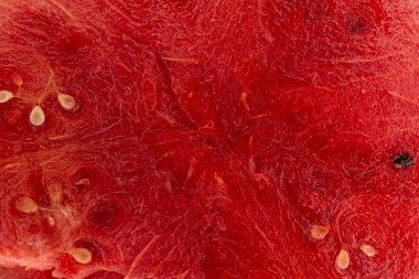 Bir karpuzun içine yakın plan, siyah tohumlu kırmızı bir yüzey metni kopyalamak için bir yere sahiptir. Arkaplan ve karpuz posası dokusu.