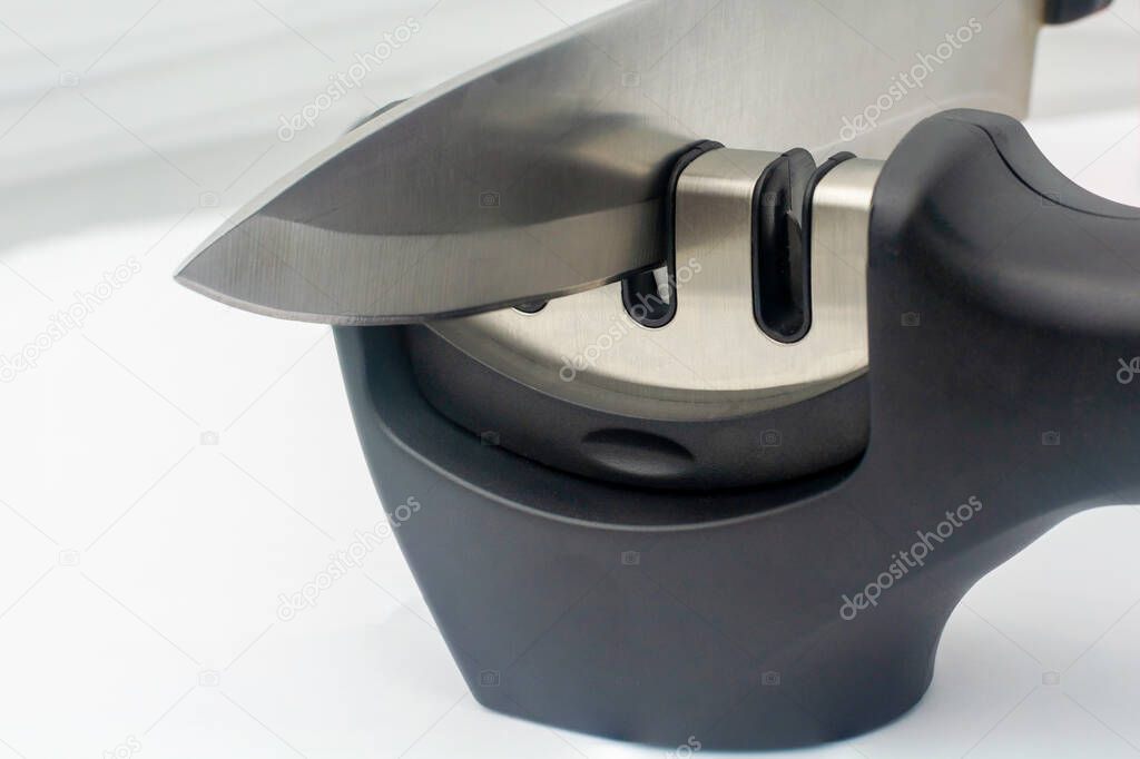 Knife - fillet knife and reversible manual knife sharpener. Items on a white background. Close-up.