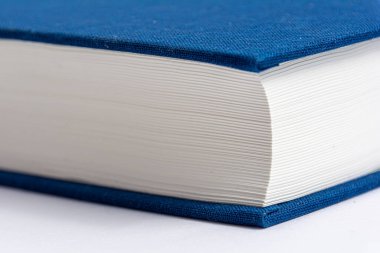 Mavi kitap kapaklı kapalı bir kitap. Yakın plan. Yan görünüm.