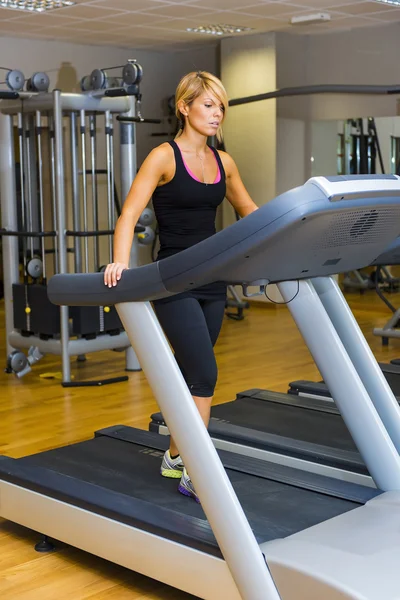 Jeune femme à la salle de gym exercice. Marcher sur une machine — Photo
