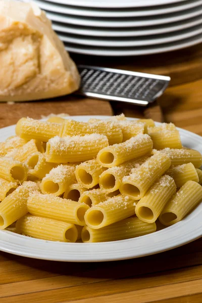 Italiaanse pasta met Parmezaanse kaas op achtergrond — Stockfoto