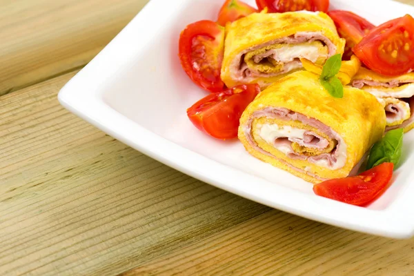 Delicious rolls omelette with tomato, ham and cheese cream — Stock Photo, Image