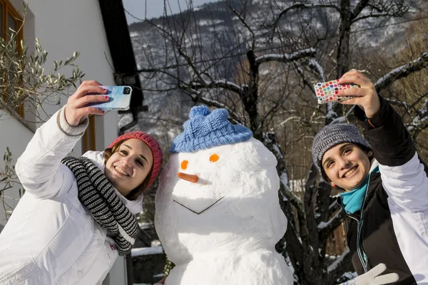 Selfie con niñas y hombre de nieve — Foto de Stock