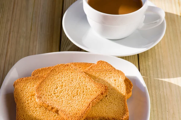 Breakfast time: cup of milky coffee and rusks — Stock Photo, Image