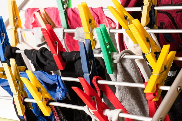 Mixed  clean laundry pinned with colourful clothespins — Stock Photo, Image