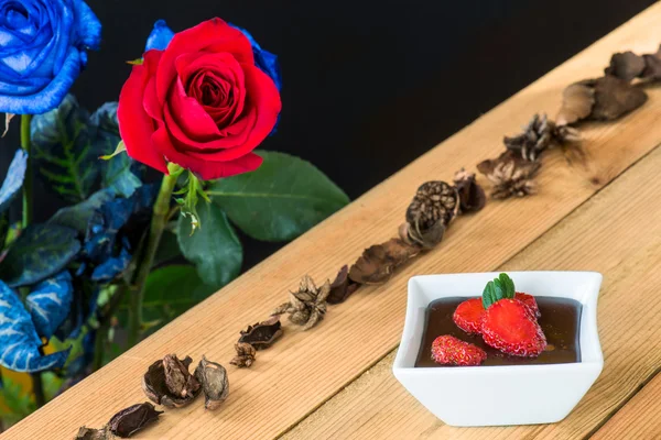 Budino al cioccolato con fragole e rose sullo sfondo — Foto Stock