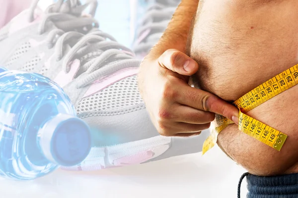 Big man measuring his belly with a measuring tape — Stock Photo, Image