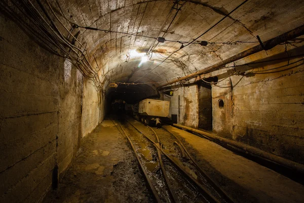 Pasaje subterráneo de la mina con rieles y vagón — Foto de Stock