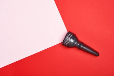 Kırmızı arka planda, kağıt fotokopi alanından yapılmış pembe bir ışık demeti olan el feneri. en üstteki görünüm