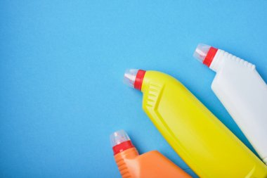 Deterjan şişeleri, mavi arka plandaki klozetler için deterjanlar. Boşluk üst görünümünü kopyala