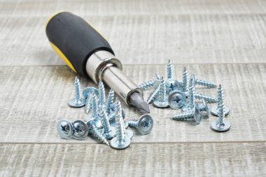 Metal için vidalar ve tahta arkaplan kopyalama alanı üzerinde değiştirilebilir nozülleri olan bir tornavida