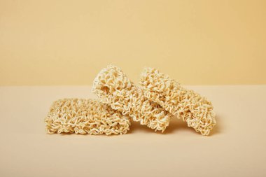 Bej arka planda üç blok kurutulmuş hazır erişte..