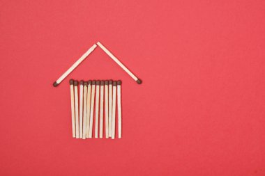 Kırmızı arkaplan kopyalama alanındaki kibritlerden yapılmış ev