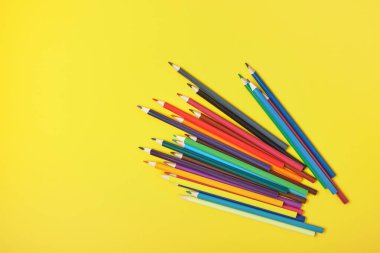 Sarı arkaplan üzerinde bir grup renkli kalem kopyalama alanı