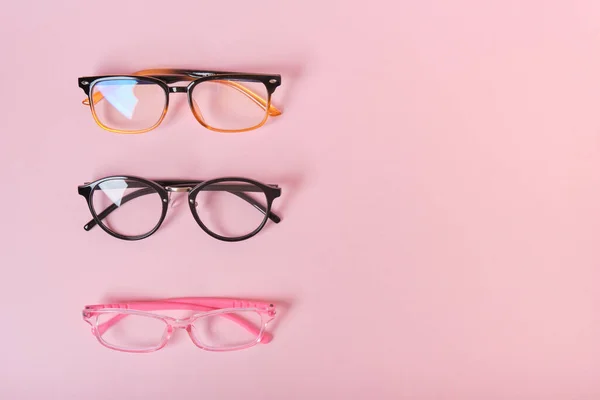 Varias Gafas Diferentes Sobre Fondo Rosa Copia Espacio Vista Superior — Foto de Stock