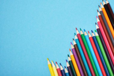 Renkli kalemler mavi arkaplan arkaplan arkaplan görünümü üzerinde bir grafik şeklinde uzanır.