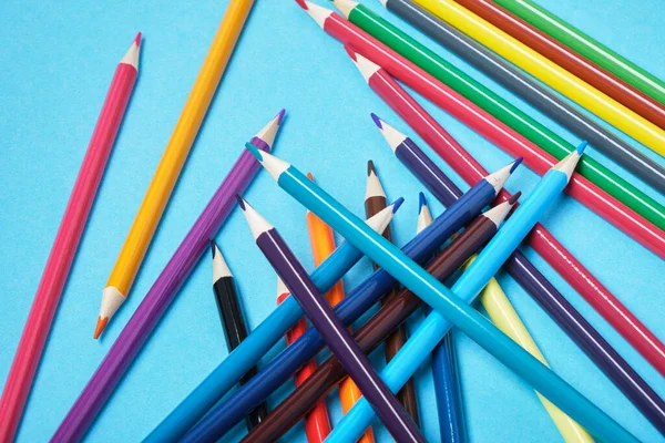 Kolorowe Ołówki Rozrzucone Chaotycznie Niebieskim Tle — Zdjęcie stockowe