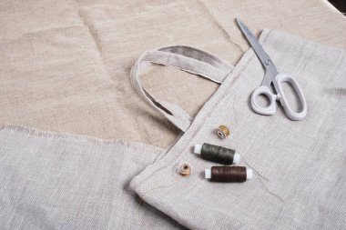 Keten kumaş kopyalama alanındaki ev yapımı eko-alışveriş makinesi, makas ve iplikler