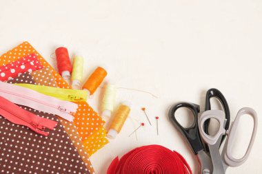 İplik makaraları, kumaşlar, fermuar ve cırt bant, dikiş konsepti üst görünümü için aksesuarlar.
