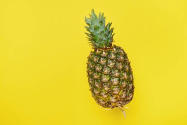 Sarı arka planda taze, uçan bir ananas. Yaz konsepti. kopyalama alanı, minimalizm.