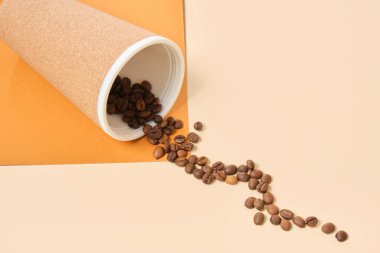 Yeniden kullanılabilir termo bardak mantar ve serpilmiş kahve çekirdekleri bej ve kahverengi geometrik arkaplan kopyalama alanı ile kaplı