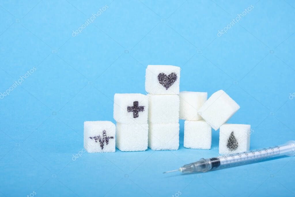 insulin syringe and a ladder of white sugar cubes on a blue background, medical symbols are drawn on the sugar heart health care and sugar harm concept