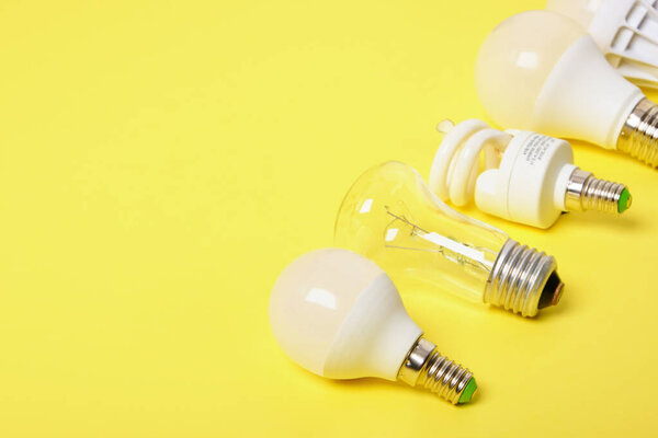 several different bulbs on a yellow background, copy space, trend color, broken and burned out bulbs for recycling