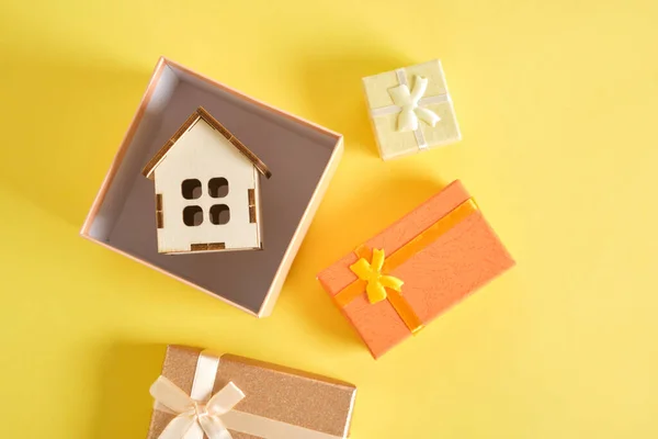 Klein Huis Model Glanzend Roze Geschenkdoos Gele Achtergrond Verschillende Kadoosjes — Stockfoto