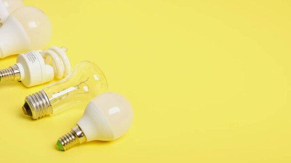 several different bulbs on a yellow background, copy space, trend color, broken and burned out bulbs for recycling