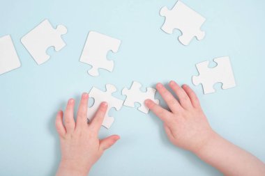 Çocuklar mavi arka planda yapboz tutuyorlar, otizm sembolü, otizm tanısı konsepti