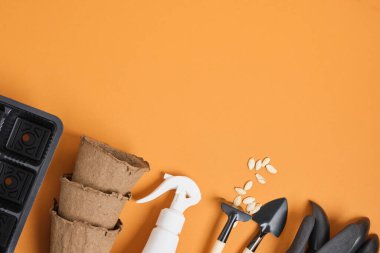 Kahverengi arkaplan üzerinde bahçe araçları metin görünümlü tohumlar, saksılar, kürekler ve bahçe eldivenleri için boşluk, üst görünümü kopyala