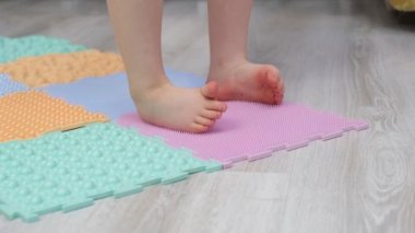 Bebek ayaklı masaj yapbozu paspası. Ortopedik masaj halısı için egzersiz. Bir çocuğun masaj masasında yürümesini önlemek için.