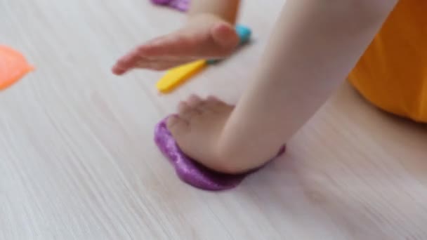 子供は木のテーブルの上で粘菌と遊び手や指の運動技術の発達子供の手の中で光る粘菌 — ストック動画