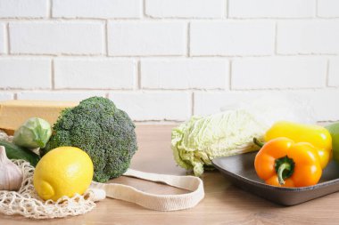 Naylon poşet içinde sebzeler ve kırsal bir mutfak masasına sarılı plastik poşet yerine yeniden kullanılabilir alışveriş yapanlara hayır deyin.