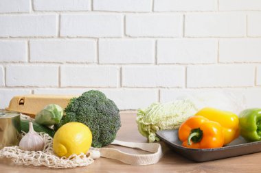 Naylon poşet içinde sebzeler ve kırsal bir mutfak masasına sarılı plastik poşet yerine yeniden kullanılabilir alışveriş yapanlara hayır deyin.