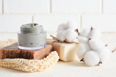 Kozmetik mavi kil, bez, lif, sabun ve pamuk çiçekleri açık arkaplanda fotokopi alanı